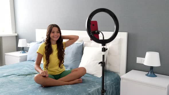 Dancing Tutorial of Happy Teen Child Blogger Making Video on Smartphone and Ring Lamp at Home Blog
