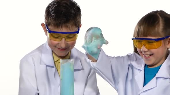 Two Cute Chemist Children Making Interesting and Successful Experiments with Blue Foam, Playing, Get