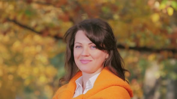 Happy Smiling and Playing Woman with Autumn Leaf in Park Romantic Mood