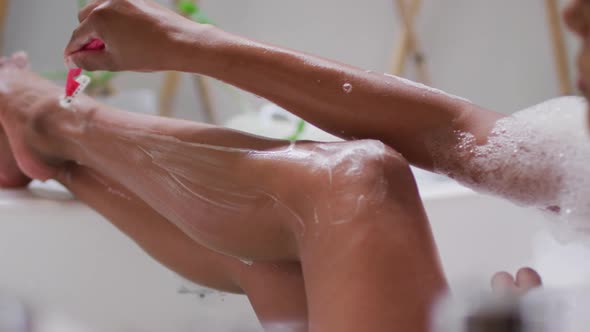 Mixed race woman lying in a bathtub at home