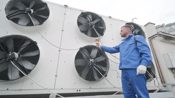 Technician uses a thermal imaging infrared thermometer to check the condensing