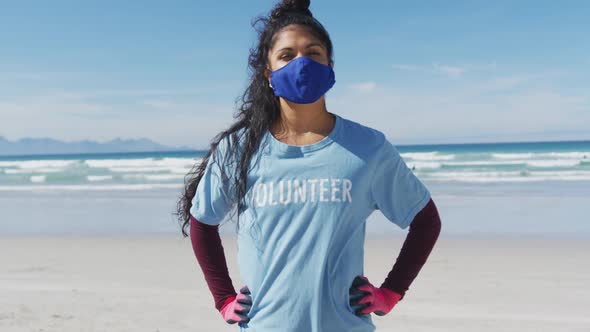 Portrait of mixed race woman wearing volunteer t shirt and face mask looking at camera