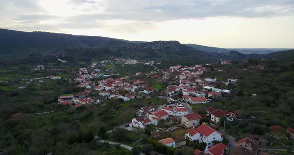 Flying over a village around Parque Natural de las Sierras de Aire y Candeeiros 