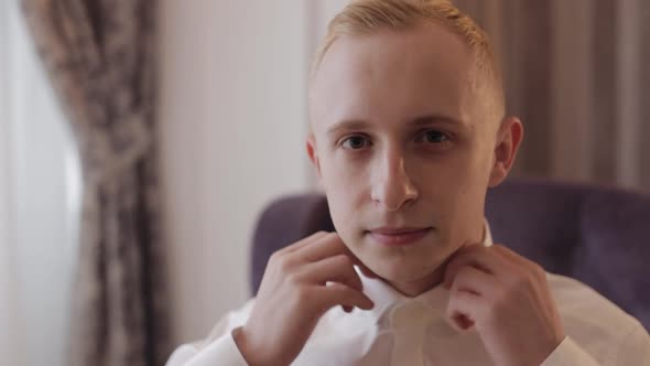 Stylish Man in Jacket Fastens Buttons Buttoning White Shirt Preparing to Go Out Near Window