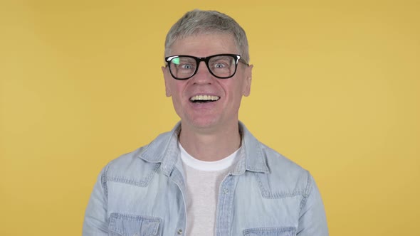 Online Video Chat By Casual Senior Man on Yellow Background