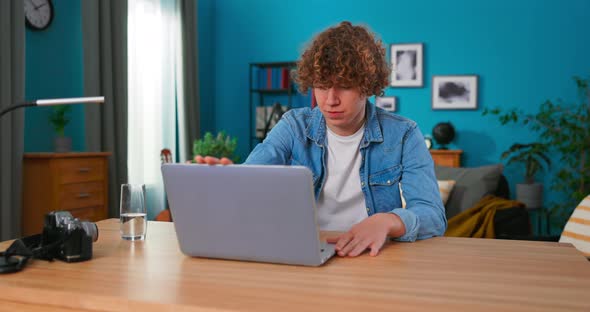 Young Teenage Man is Studying with a Laptop in Her Bedroom
