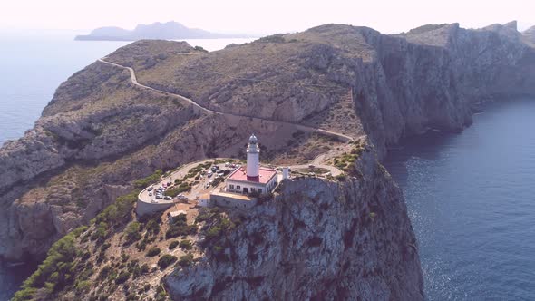 Lighthouse on rocky seashore with curved road