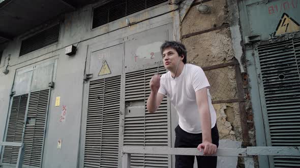 Adult Man Standing on Background of Grey Old High Voltage Doors