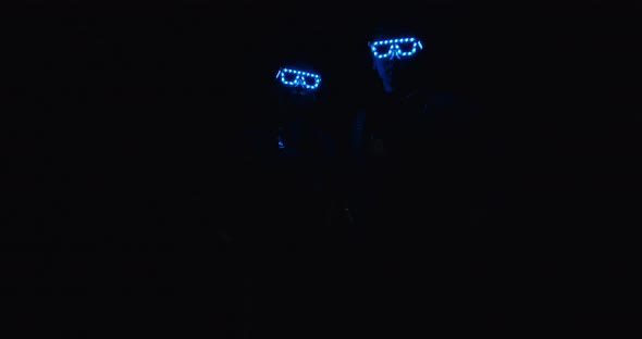 Light Show, Two People Appear in the Dark with Glowing Glasses, 