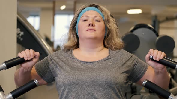 Woman Doing Fitness Exercises on Chest Press Machine at the Gym