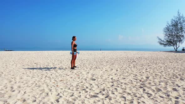 Women tan on idyllic resort beach break by transparent water and white sand background of Thailand b