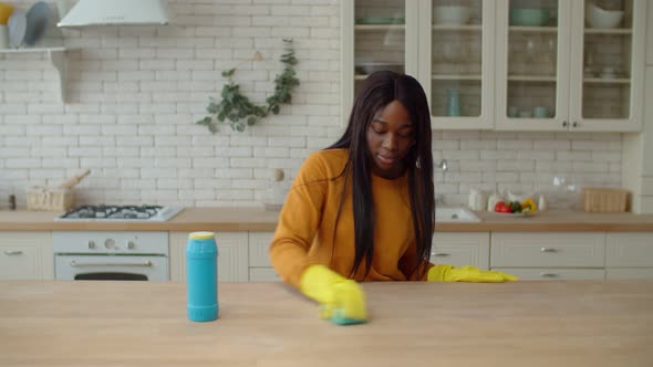 Lovely African Teenage Girl Cleaning Table Surface