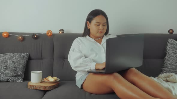 Asian Plus Size Woman Working Online with Laptop at Home