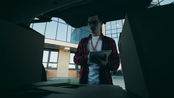 A Man Is Taking Out Boxes for Delivery From the Car Trunk