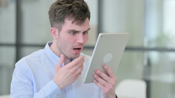 Young Man Reacting to Loss on Tablet