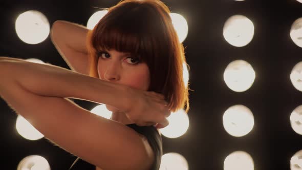 Beautiful woman dancing in front of a wall of lights