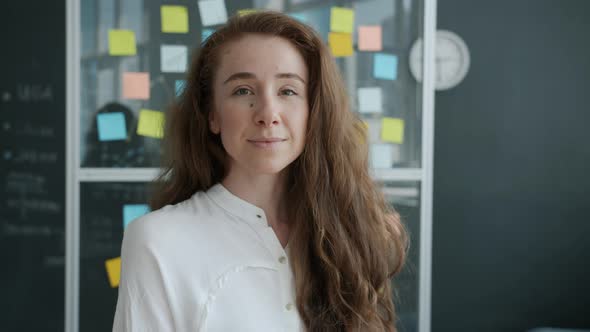 Portrait of Attractive Young Woman Employee Smiling Indoors in Creative Office