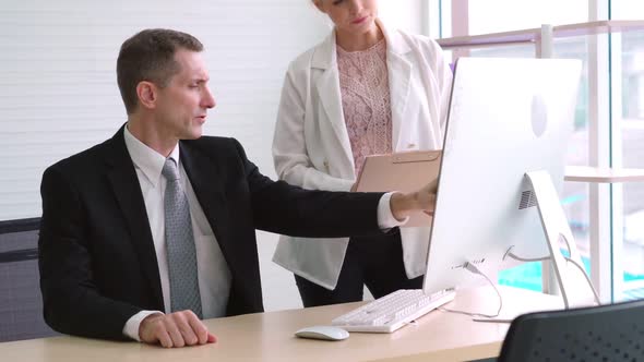 Two Business People Talk Project Strategy at Office