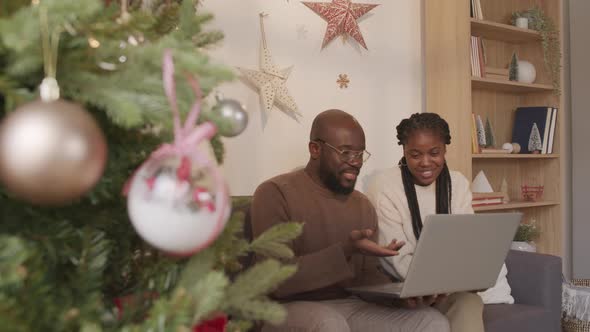 Black Man and Woman Using Laptop at Christmas