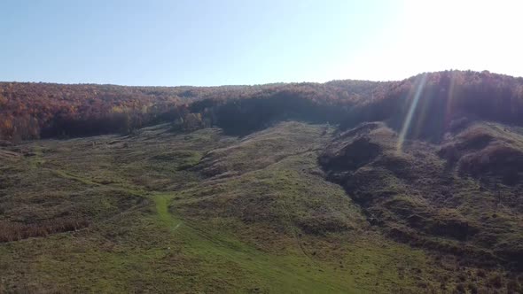 Aerial view of country hills at sunset in autumn season. Beautiful rural scene with dead nature, ear