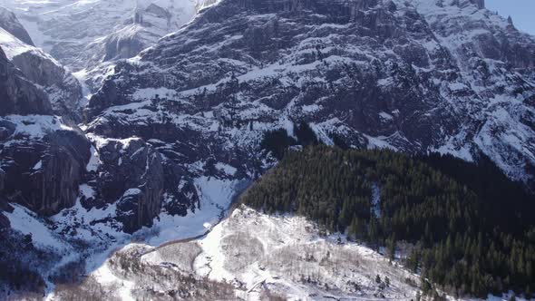 aerial footage flying over snowy glacial landscape over a river in direction of big limestone cliffs