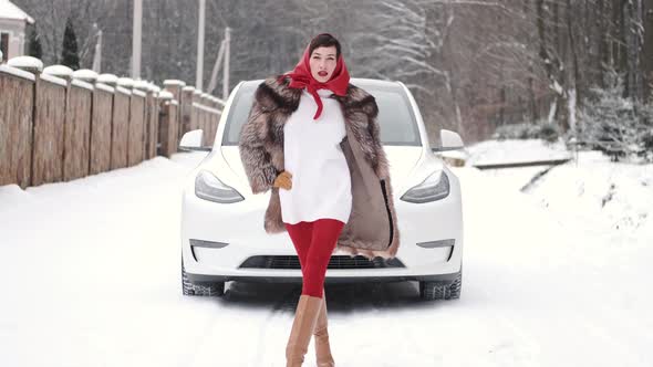 Stylish Woman in Fur Coat and Head Scarf in Winter Backyard