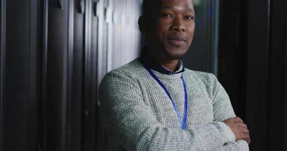 African american male computer technician with security pass in business server room