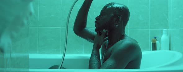 African American Man Showering in Bathtub
