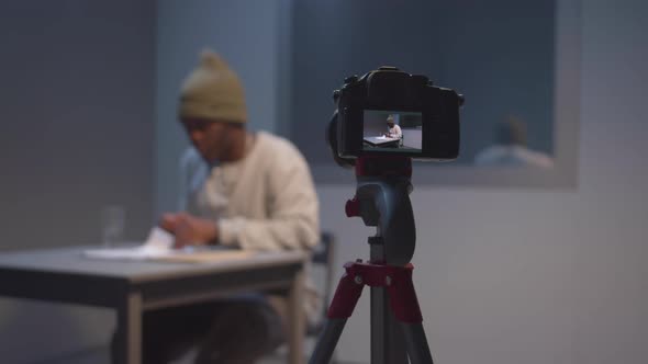 Witness Examines Documents Under Camera Surveillance