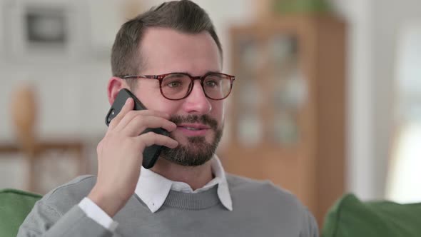 Middle Aged Man Talking on Smartphone at Home