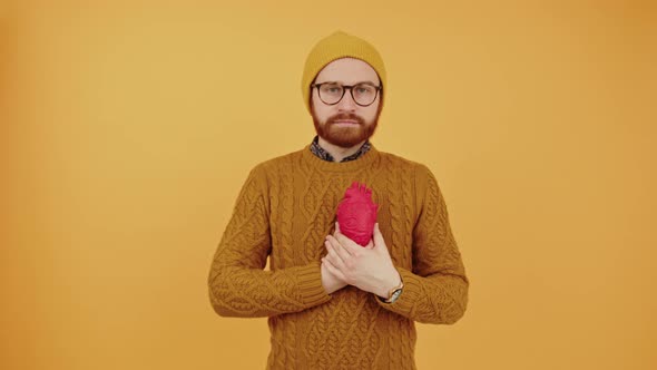 Goodlooking Stylish Bearded Man Wearing Mustard Sweater Holding an Heart 3d Model Next to His Chest