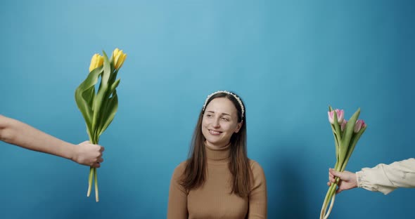 Sisters with Tulips Flowers Giving to Mom on a Blue Background Happy Mother