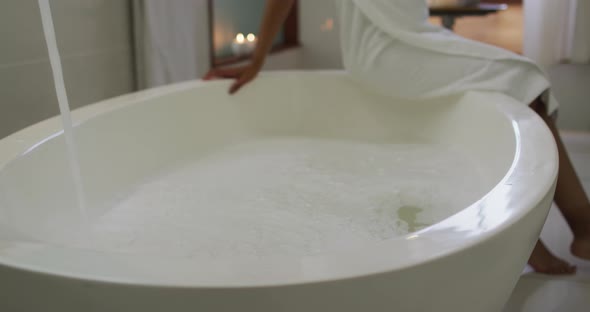 Mixed race woman running a bath