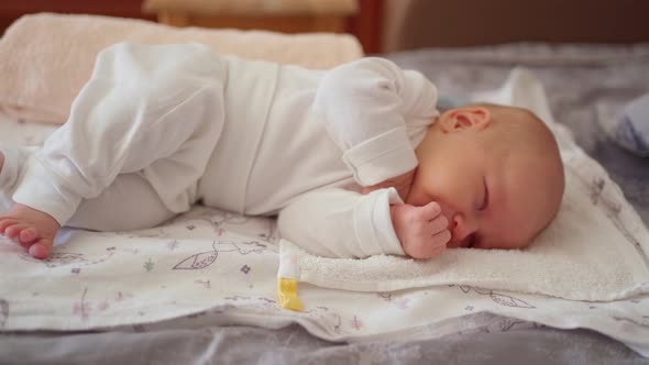 a Small Newborn Baby Lies on a Diaper and Sleeps