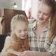 Young Mother in a Plaid Shirt and with a Ponytail Hugging a Cute Baby Girl - VideoHive Item for Sale
