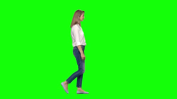 Blonde Woman Is Calmly Walking and Smiling on Green Screen. Chroma Key. Profile View. Slow Motion