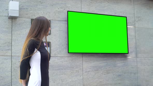 Young Smiling Business Woman Giving Presentation on Big Green Screen