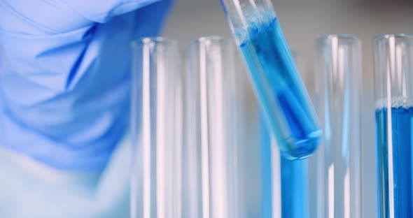 Working in Lab - Scientist Holding Test Tubes and Analyzing Liquid alt