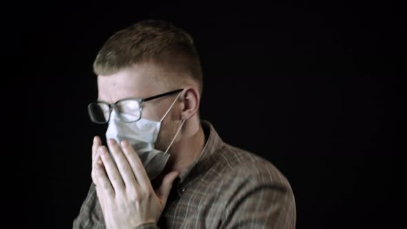 Young Caucasian Infected Man Coughs Hard in Medical Mask Against Coronavirus