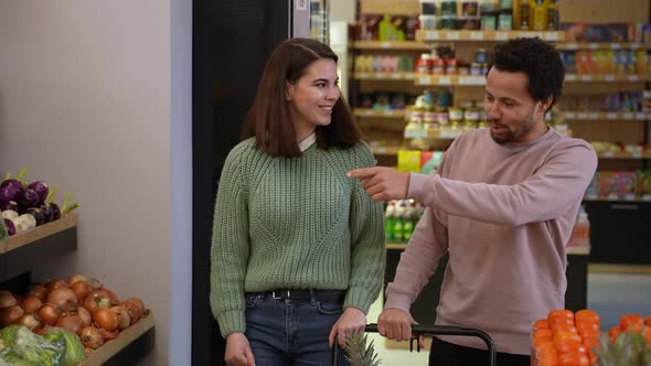 Joyful Couple Carrying Grocery Cart in Farm Store