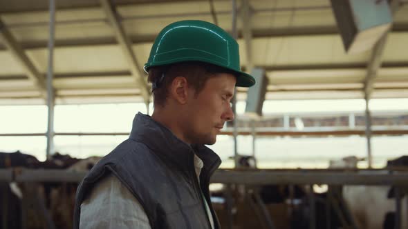 Man Farmer Walking Cowhouse in Helmet Closeup