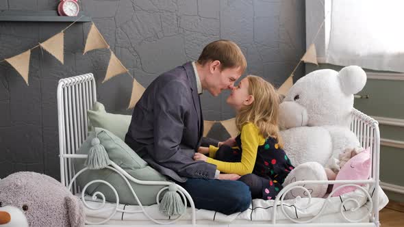 Little Girl with Her Father Rubbing Noses Indoors
