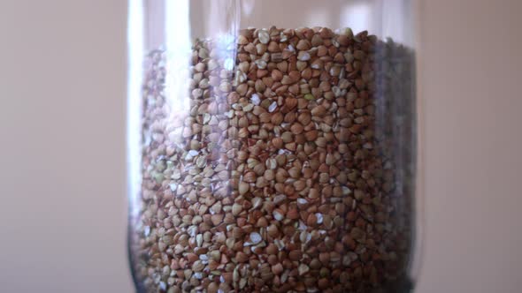 Raw Buckwheat Groats Spinning in a Glass Jar Close Up