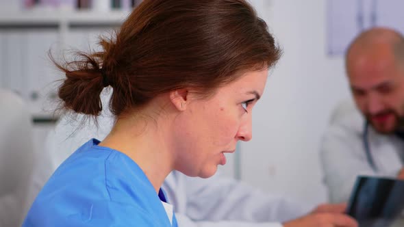 Close Up of Young Woman Nurse Discussing with Colleague