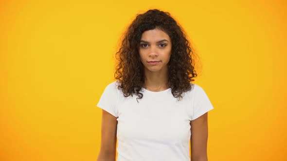 Serious Biracial Woman Showing No Gesture to Camera Against Yellow Background