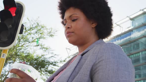 Plus size biracial woman eating salad in city