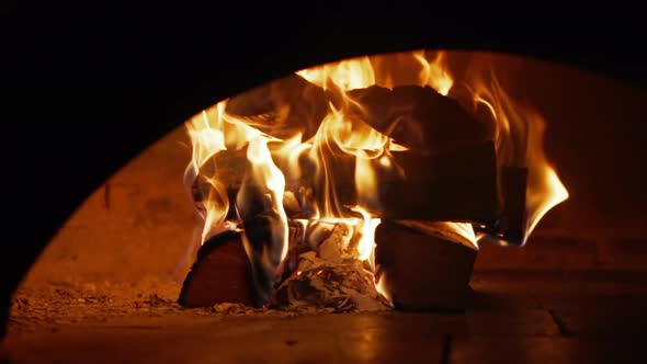 Log on Fire Inside a Brick Oven at the Restaurant