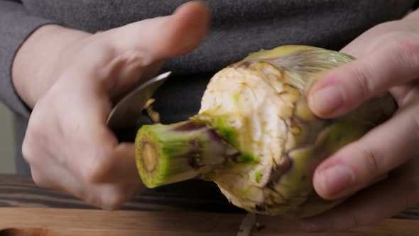 Woman Cleaning Artichokes with Knife