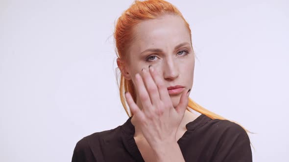 Confident Middleaged Caucasian Female in Dark Brown Shirt Touching Her Face and Smiling Then Leaving