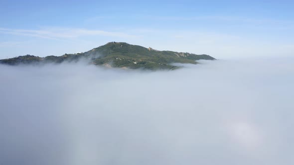 Aerial View Green Mountain Covered By Thick Fog Clouds at Sunrise. Malibu, USA